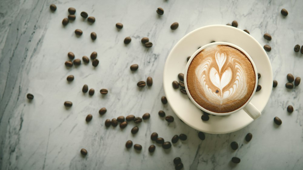 Tasse de café et grains d'arabica sur un plan en marbre
